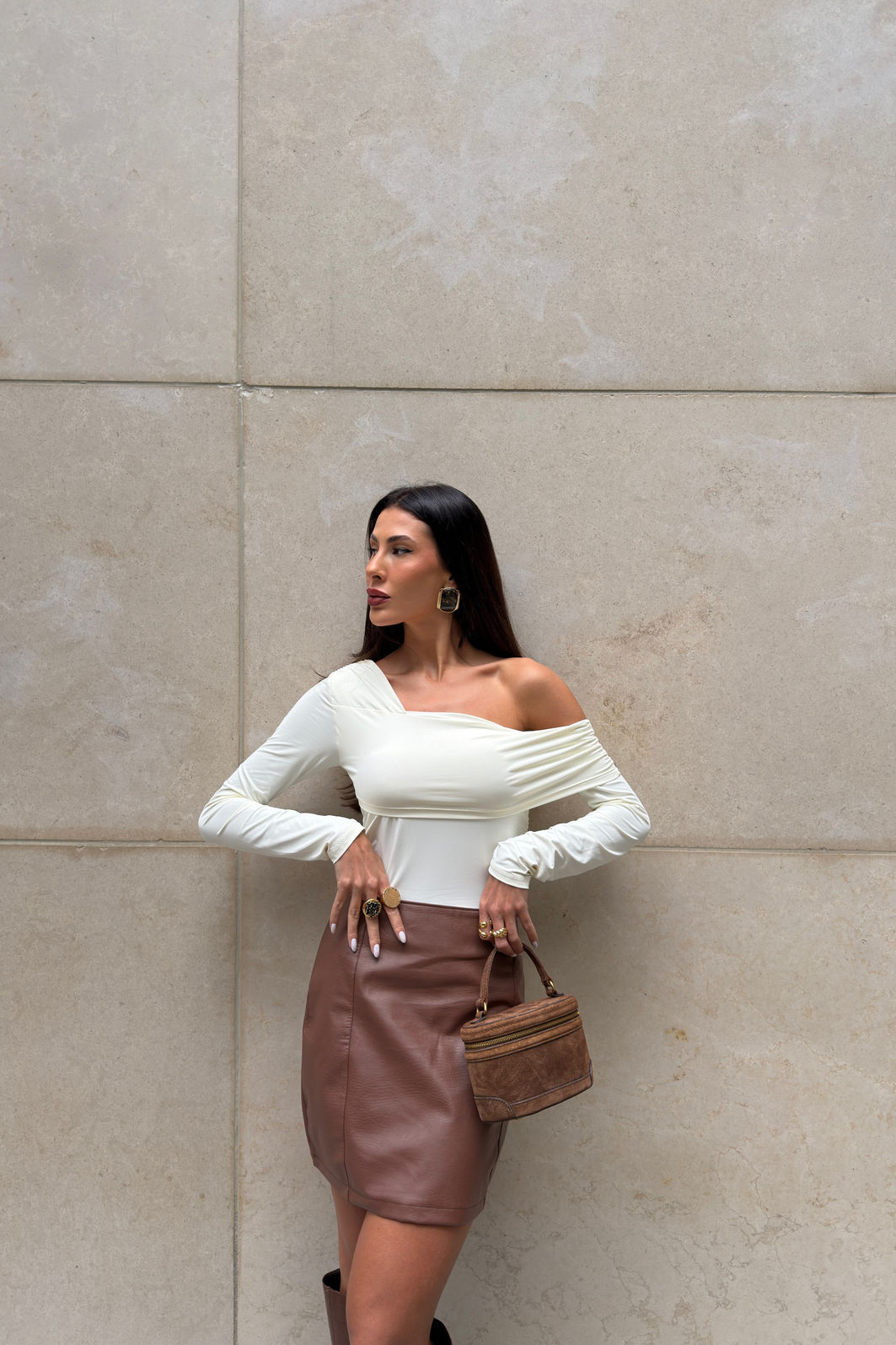 SAIA DE POLIUTERANO COM RECORTES DAYDREAM MARROM Saia feminina marrom em poliuretano com cintura alta e recortes verticais, modelagem ajustada e visual sofisticado tipo couro em look moderno com bota alta