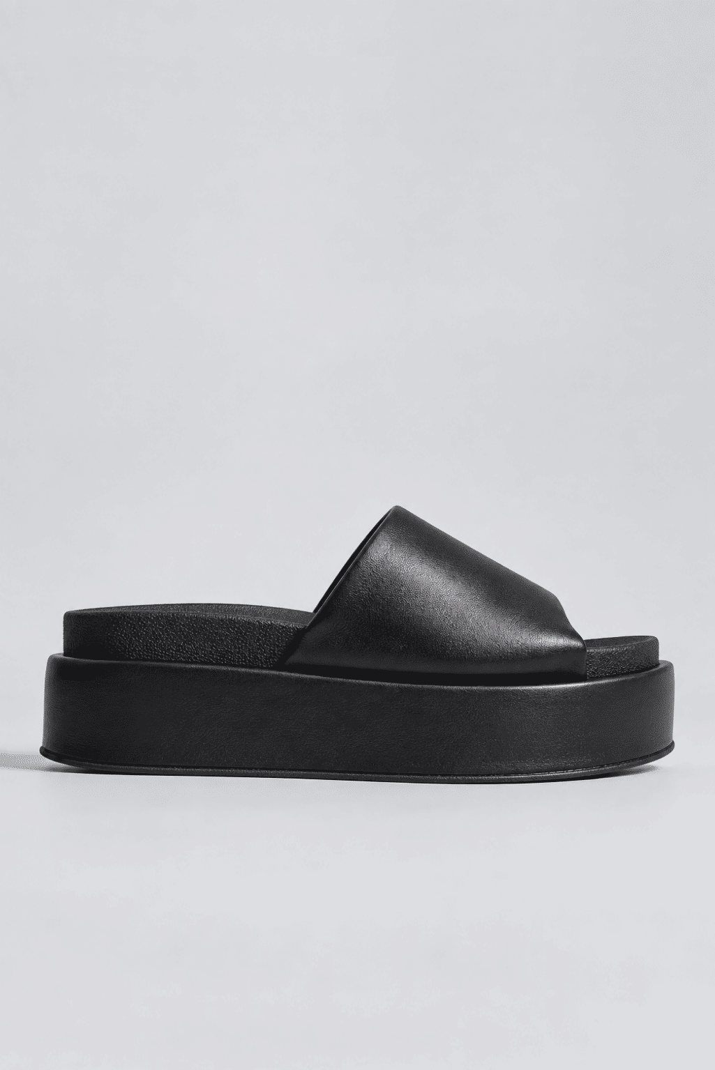 tamanco-plataforma-feminino-tira-acolchoada-preto-fifi Tamanco plataforma feminino preto com tira acolchoada, vista lateral, isolado em fundo cinza claro.