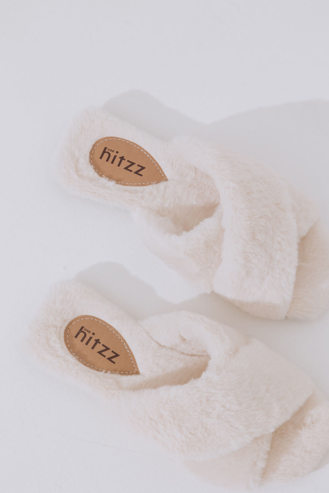 rasteira-feminina-pelos-off-white-ayla Par de rasteiras de pelos off white Ayla com palmilha marrom logo Hitzz, vista superior