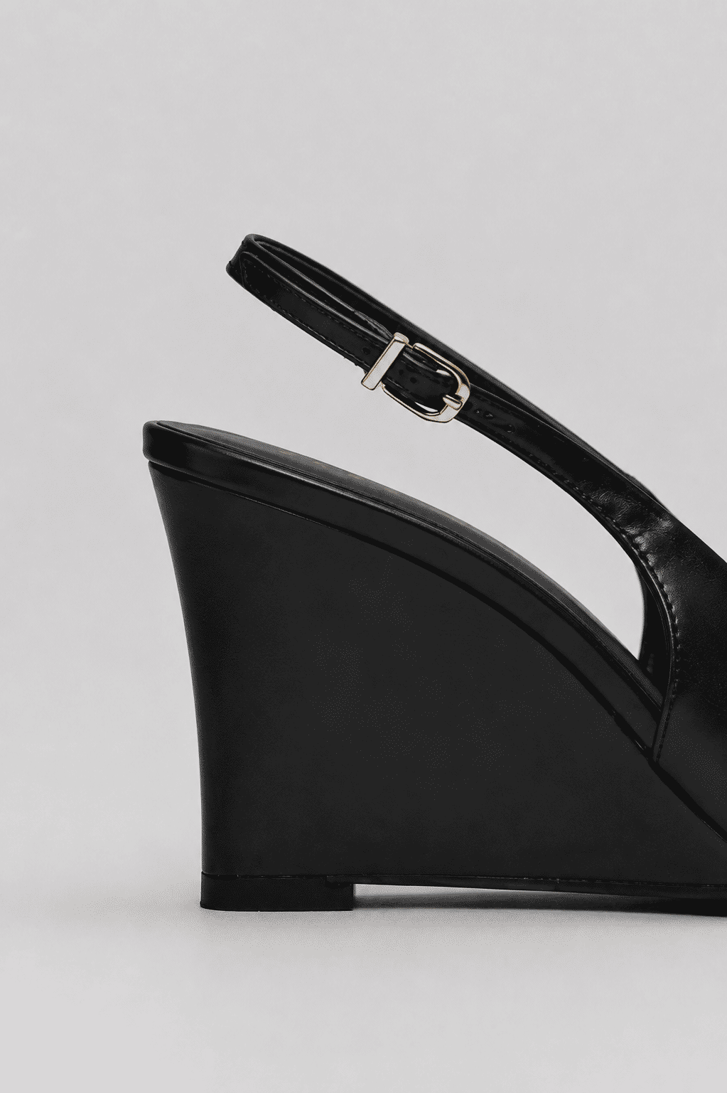 Detalhe Salto Naomi Preto Close do salto anabela preto e da tira traseira com fivela ajustável do slingback feminino Naomi preto.