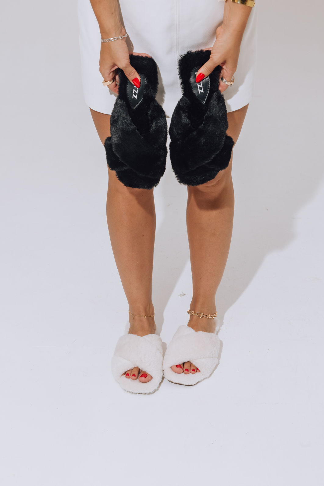 rasteira-feminina-pelos-off-white-ayla Mulher de short preto usando rasteira feminina de pelos off white Ayla