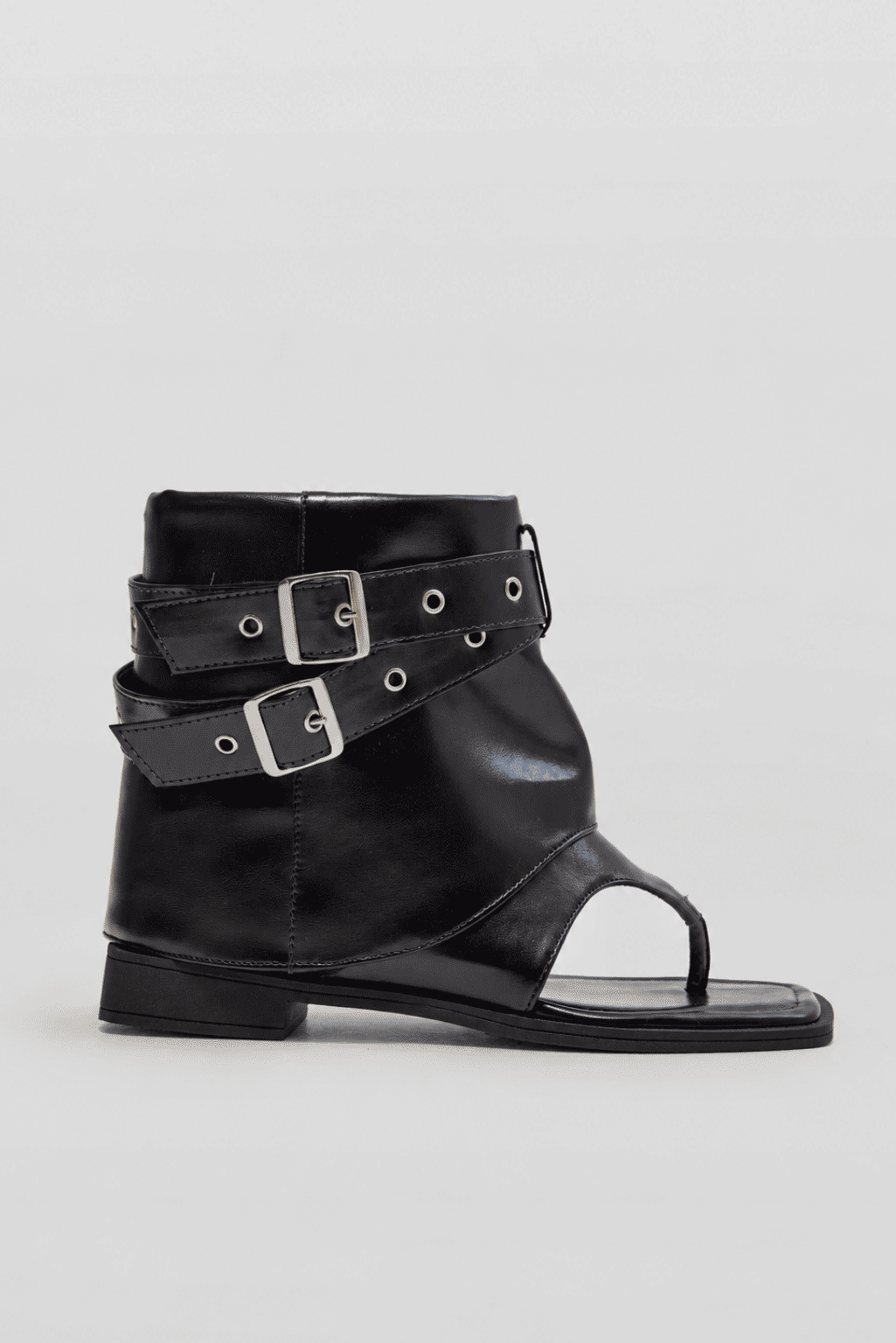 eva-sandalia-feminina-rasteira-fivelas-preta Bota sandália feminina preta com bico quadrado, tira de dedo, duas fivelas ajustáveis e salto baixo de aproximadamente 2 cm, vista lateral em fundo cinza.