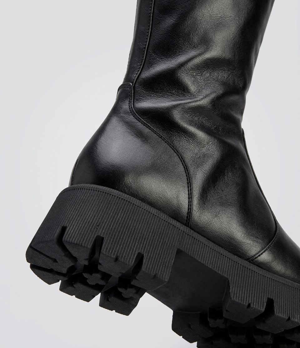 zuna-bota-feminina-cano-longo-tratorada-preta Detalhe do solado tratorado da bota feminina Zuna preta em couro, vista aproximada