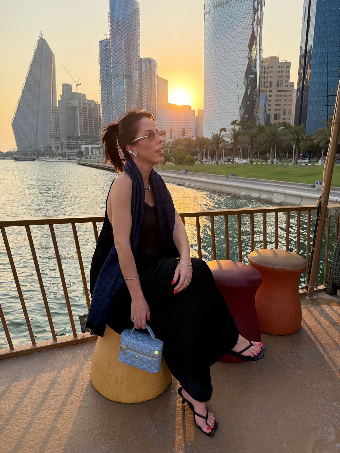agnes-bolsa-feminina-lateral-matelasse-jeans Mulher usando Bolsa Feminina Matelassê Agnes jeans em produção casual, destacando o tamanho e o formato do modelo.