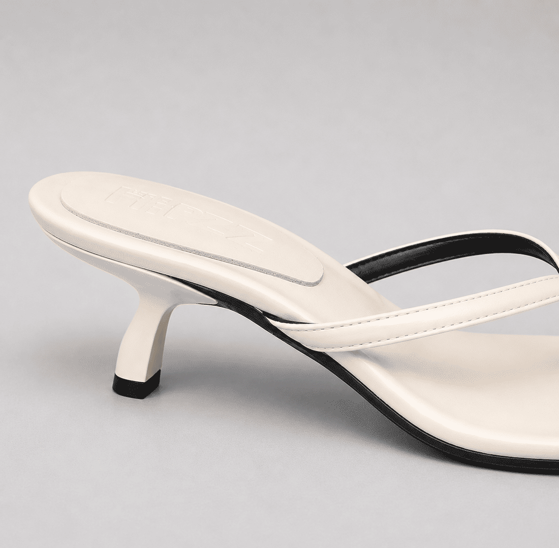hanna-tamanco-feminino-off-white Tamanco Feminino Couro Dedo Salto Hanna off white, vista do par, com tiras finas de dedo, salto baixo curvado e bico irregular