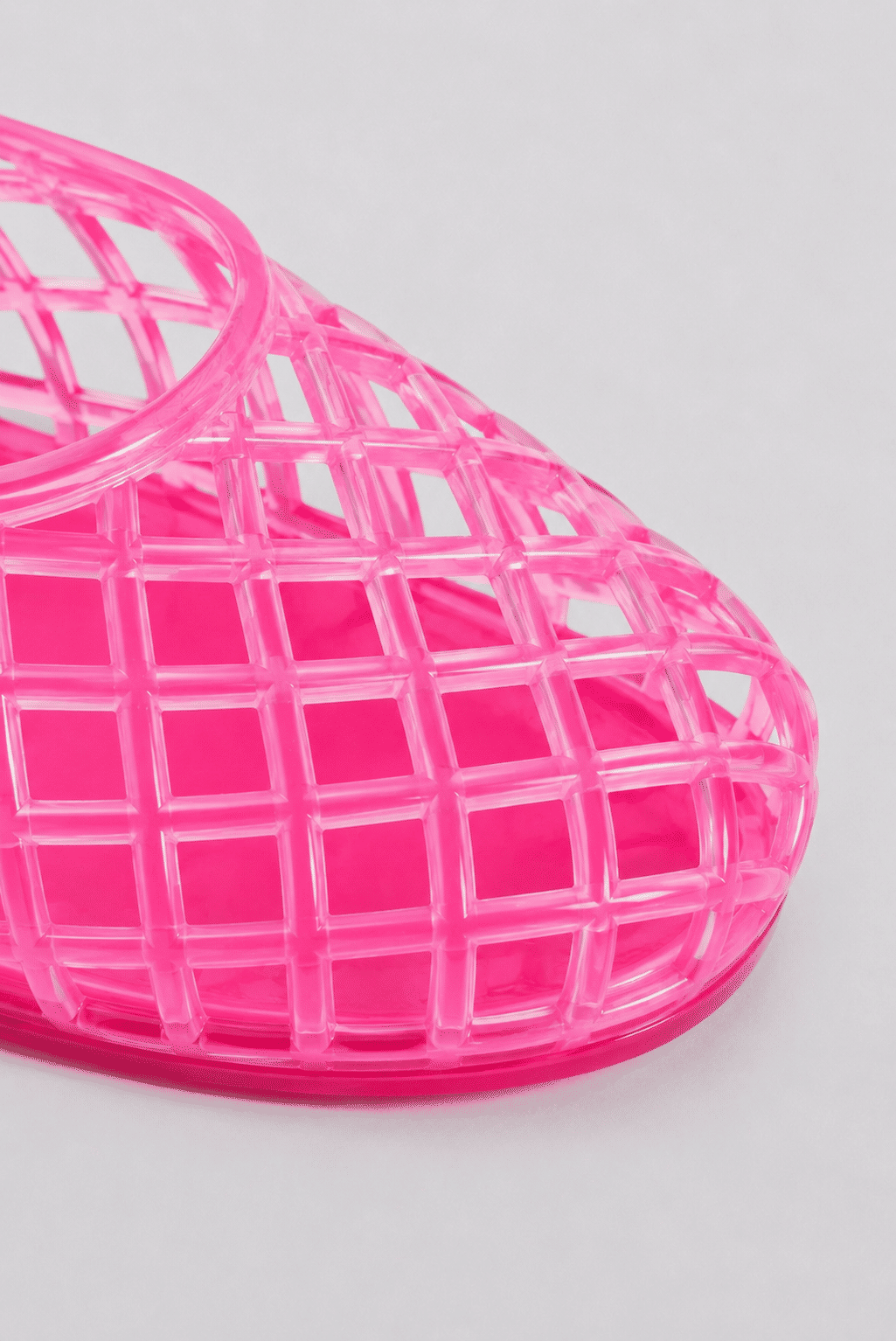 sapatilha-feminina-rosa-gummy Detalhe macro da trama entrelaçada em PVC da Sapatilha Feminina Rosa - Gummy, evidenciando a transparência e o acabamento vazado.