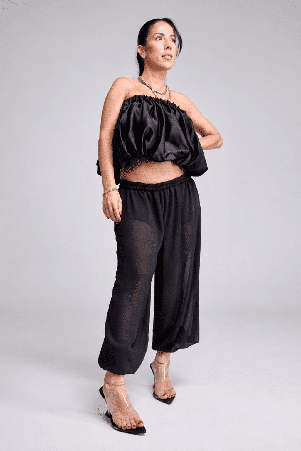 tamanco-feminino-tiras-de-vinil-preto-miranda Modelo em pé, corpo inteiro, look total black tomara que caia, calçando o Tamanco Feminino Tiras de Vinil Preto - Miranda