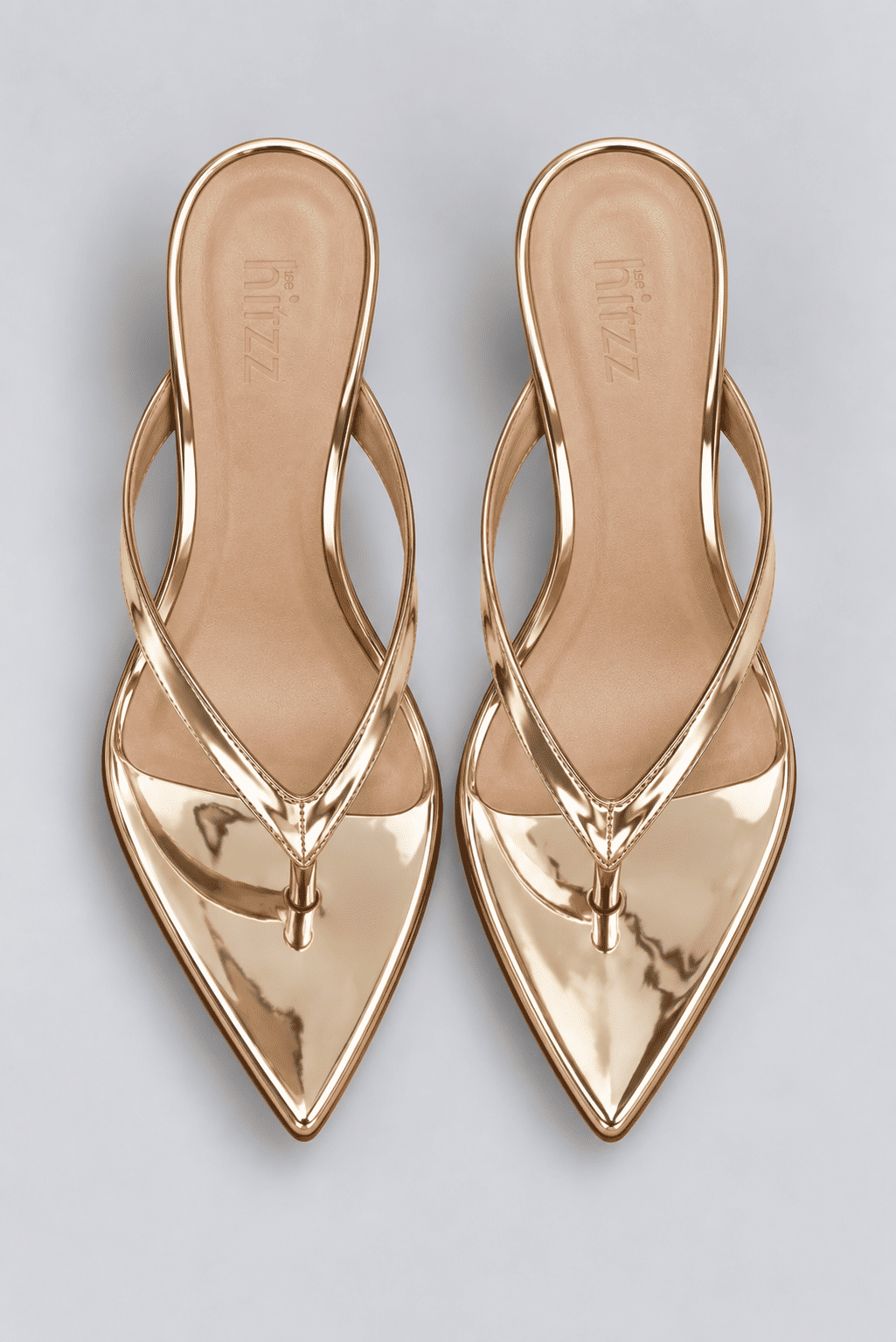 tamanco-feminino-dedo-salto-anabela-bico-folha-ouro-light-liz Par de tamancos dedo dourado metalizado vistos de cima, palmilha com a marca hitzz gravada, bico folha em destaque.