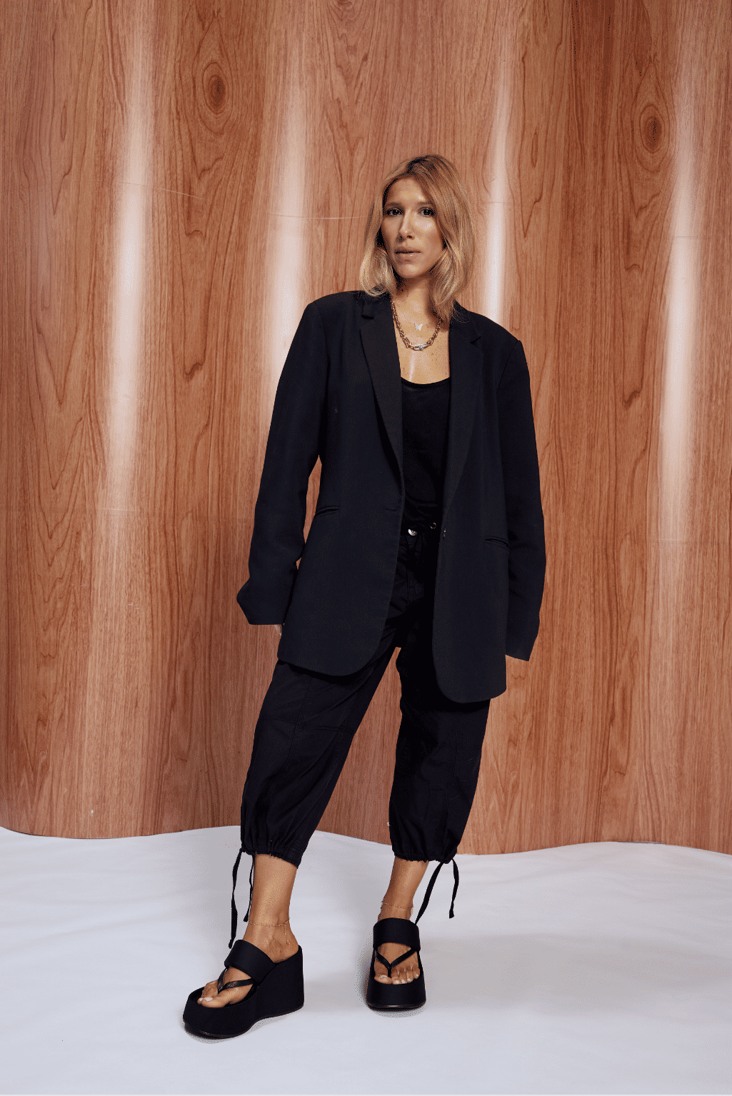 nyx-tamanco-femnino-tira-de-dedo-preto Tamanco Feminino Nyx preto nos pés, combinado com look all black de blazer e calça cargo.