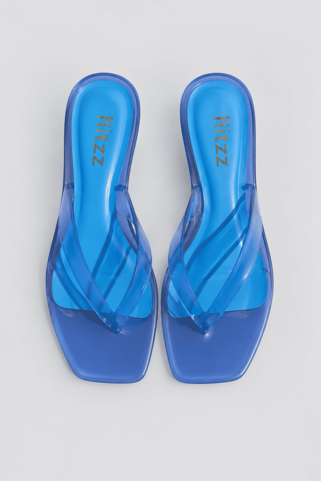 gummy-tamanco-salto-baixo-transparente-azul Tamanco Feminino Flip Flop Azul - Gummy visto de lado, tira em vinil transparente azul e salto fino translúcido baixo