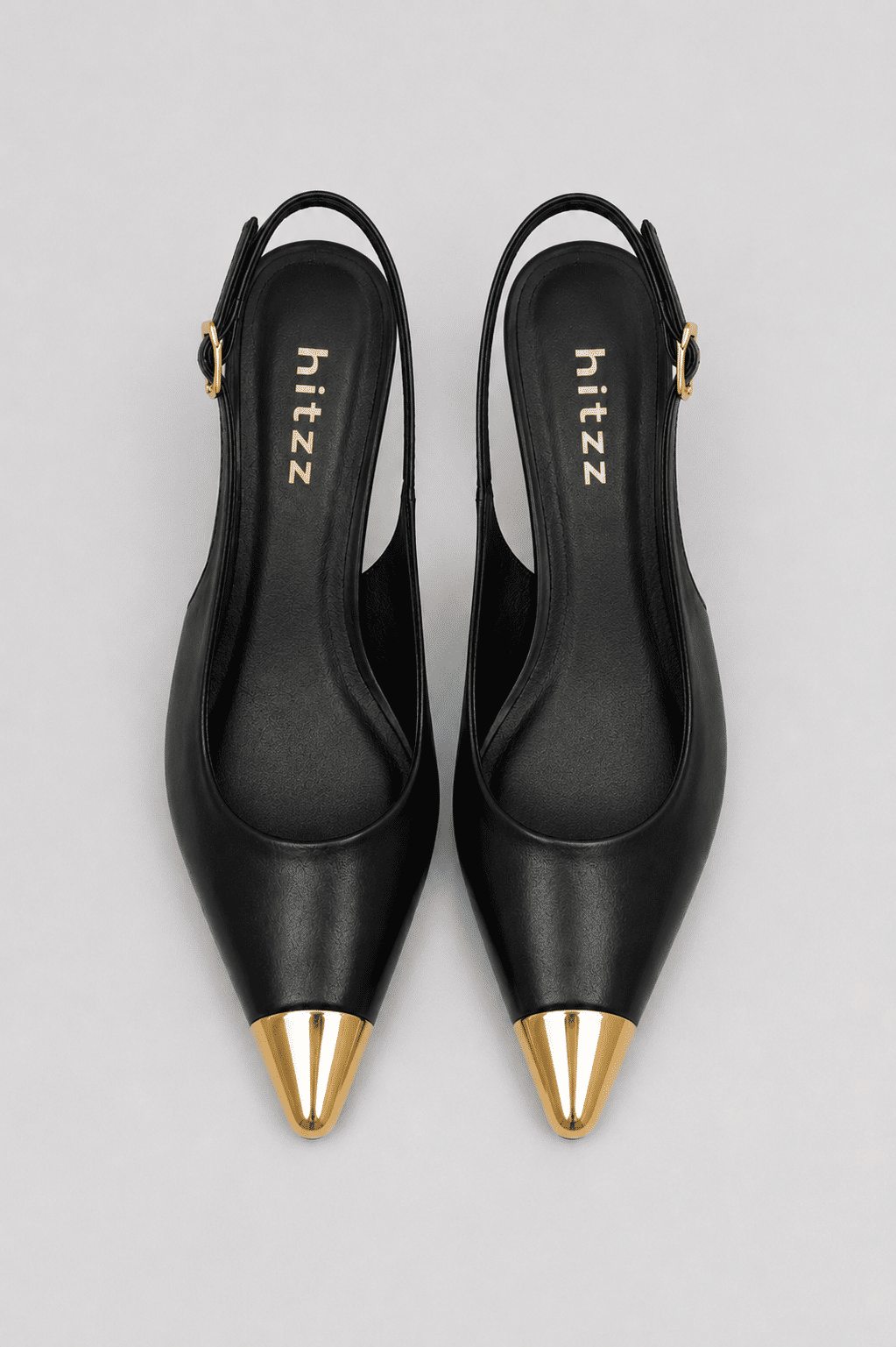 Slingback Naomi Preto Vista Superior Par de slingbacks femininos Naomi pretos em vista superior, destacando o formato do cabedal, a palmilha e o bico fino com ponteira metálica dourada.