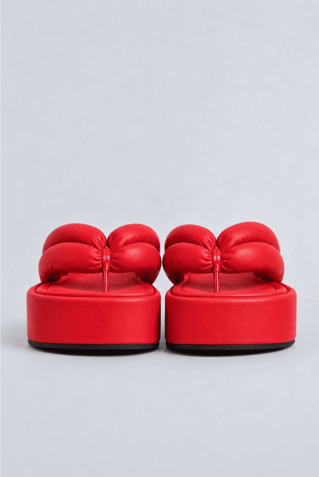 chinelo-flatform-tiras-puffer-vermelho-sakura Par do Chinelo Flatform Tiras Puffer Vermelho - Sakura visto de frente, destacando as tiras acolchoadas e a plataforma flatform