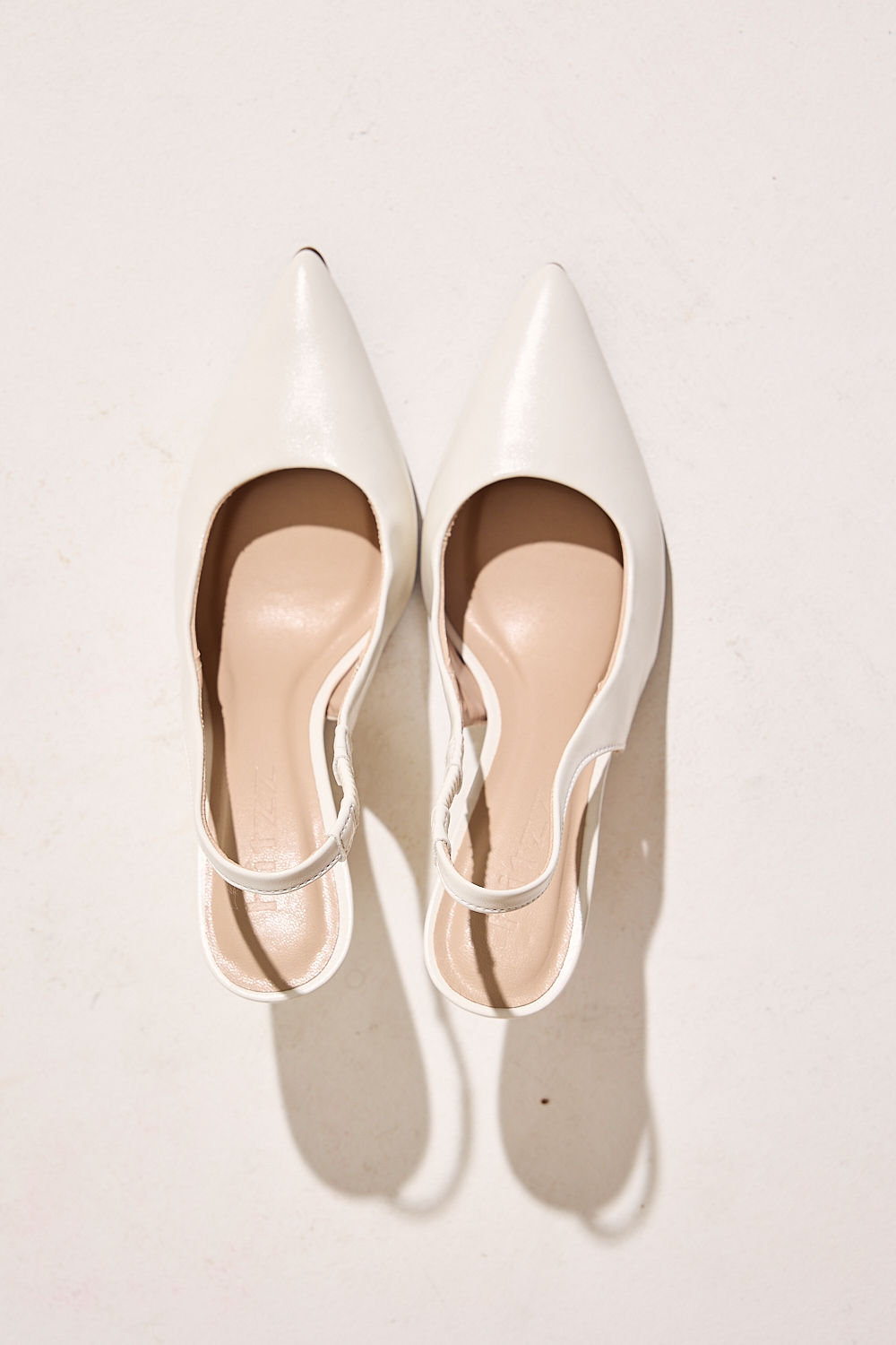 scarpin-feminino-salto-anabela-slinback-off-white-suzan Par de scarpins femininos salto anabela off white, vista superior mostrando o bico fino