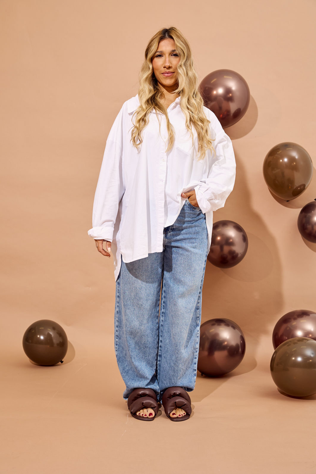 flat-rasteira-feminina-puffer-marrom-lala Flat rasteira feminina puffer marrom Lala - modelo de corpo inteiro com camisa branca oversized e calça jeans wide leg