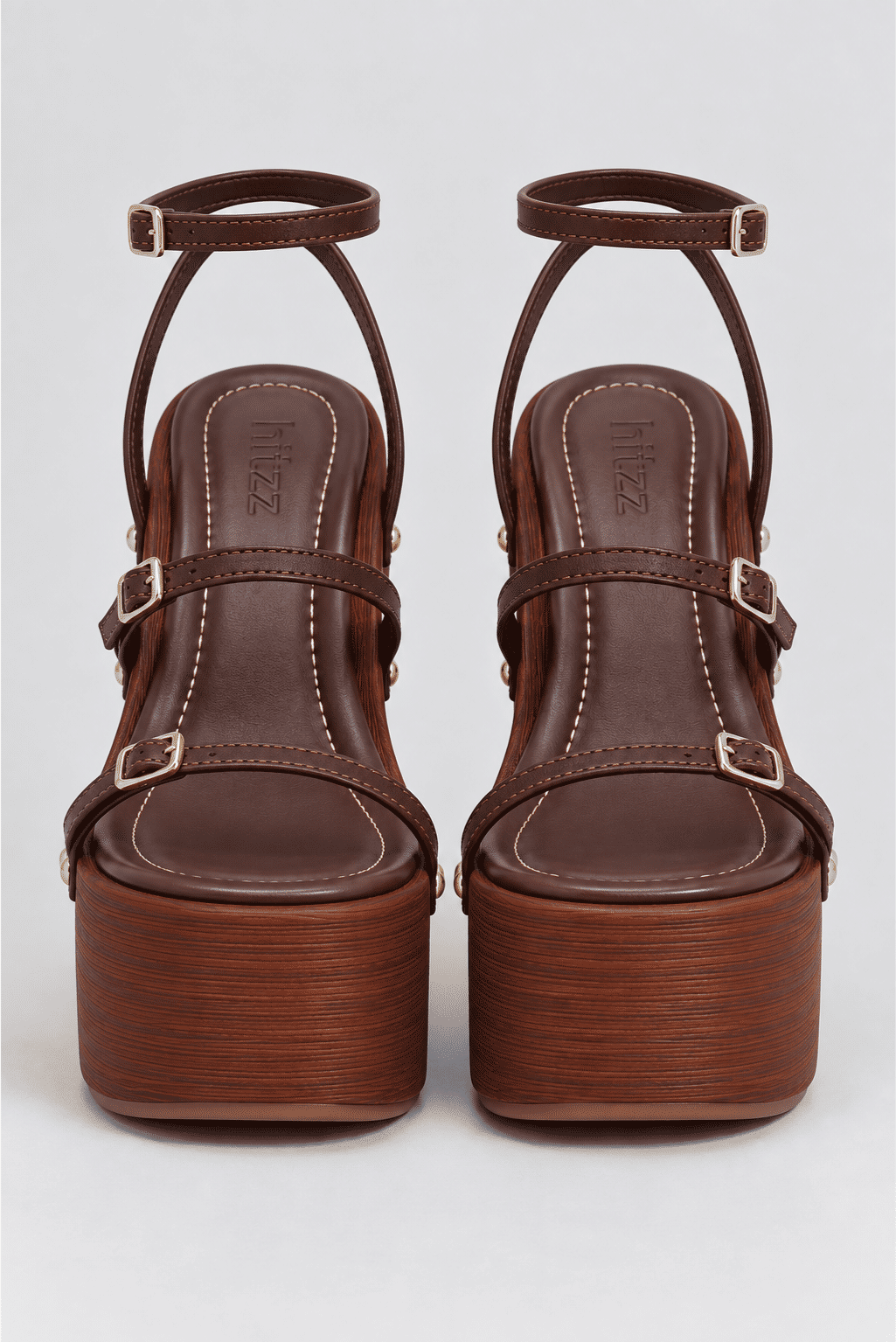 sandalia-plataforma-feminina-tiras-camel-bronx Par da Sandália Plataforma Feminina Tiras Camel Bronx visto de trás, com tiras cruzadas e fivelas douradas