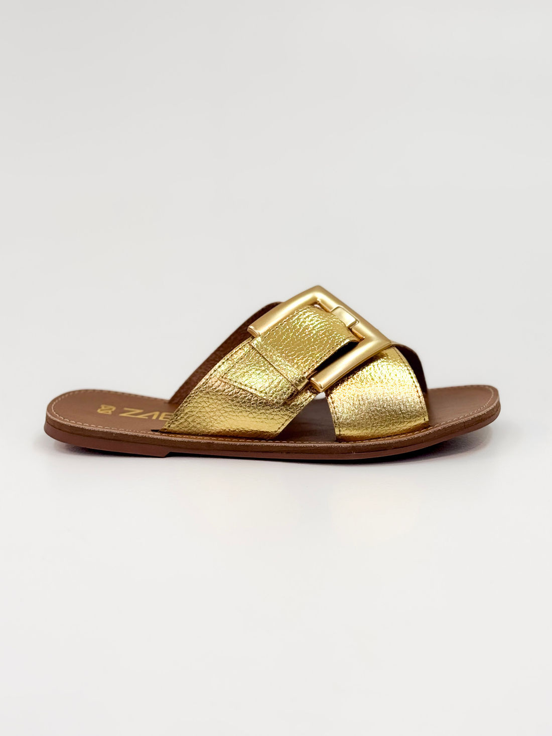 Joanice — Chinelo Rasteira Ouro com Fivela Dourada Joanice — Chinelo Rasteira Ouro com Fivela Dourada