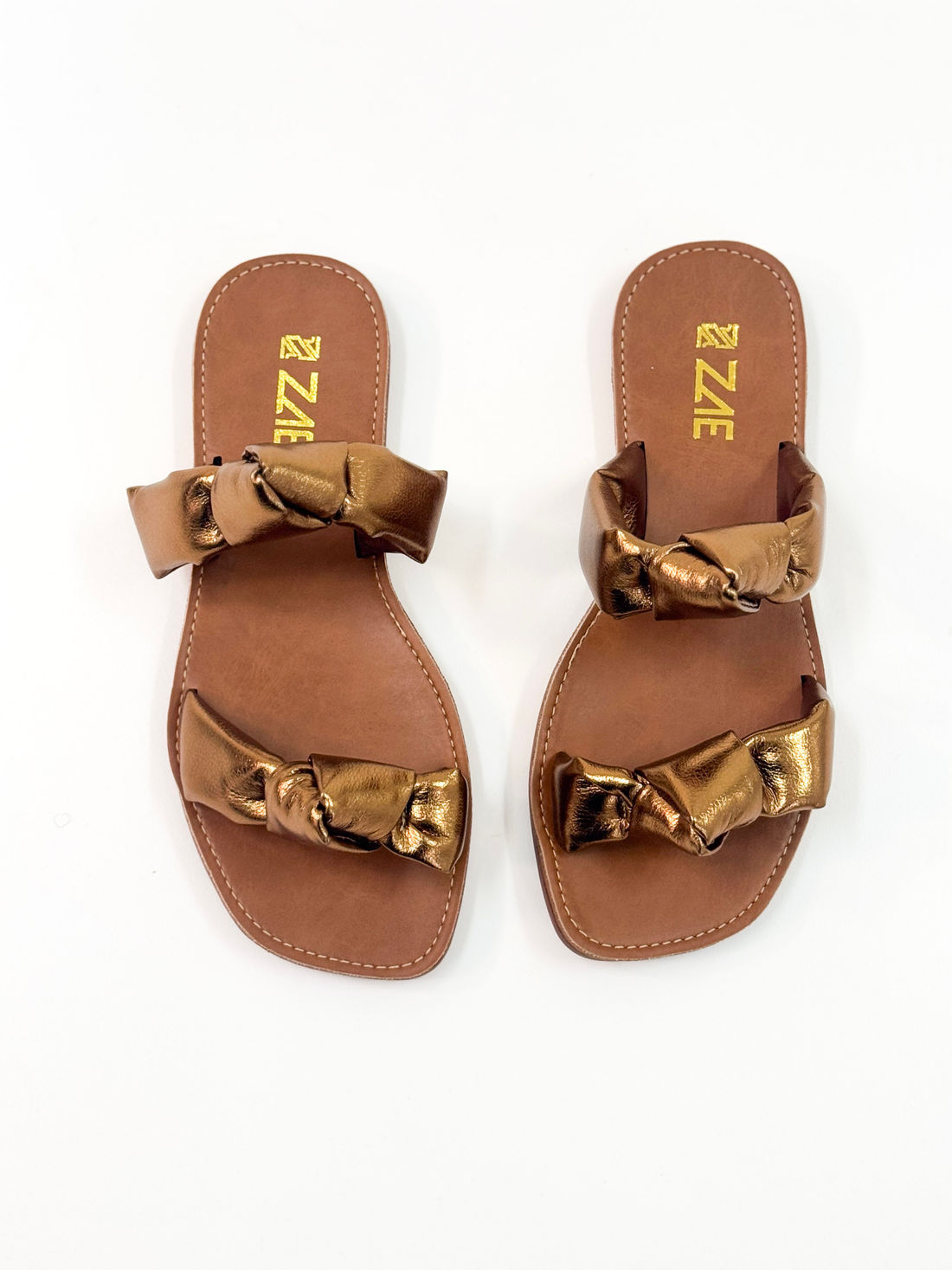 Luana — Chinelo Rasteira Bronze com Tiras Torcidas Luana — Chinelo Rasteira Bronze com Tiras Torcidas