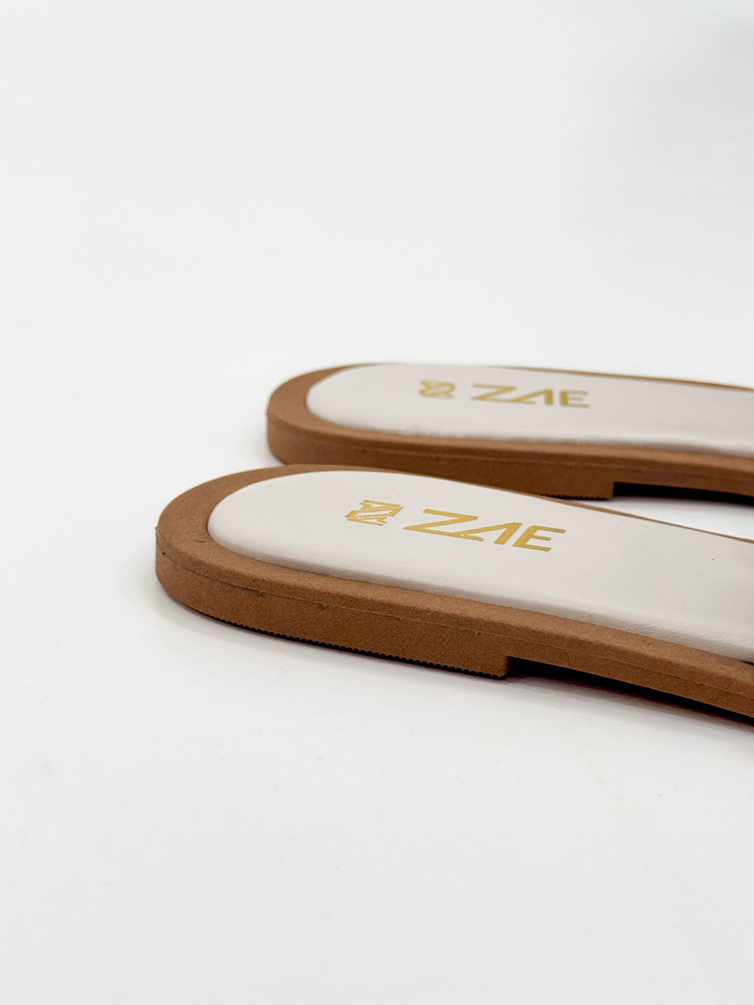 Clau – Chinelo Rasteira Off White com Detalhe Metálico Dourado Clau – Chinelo Rasteira Off White com Detalhe Metálico Dourado