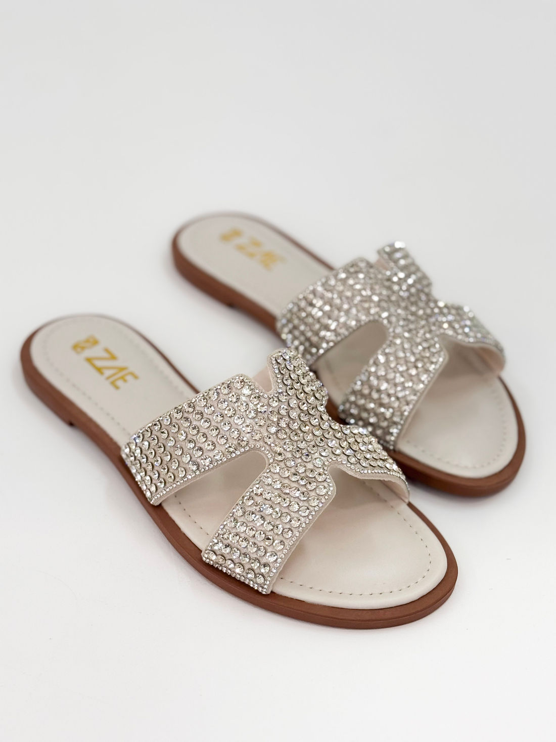 Clarice — Chinelo Rasteira Off White com Tiras Prateadas Clarice — Chinelo Rasteira Off White com Tiras Prateadas