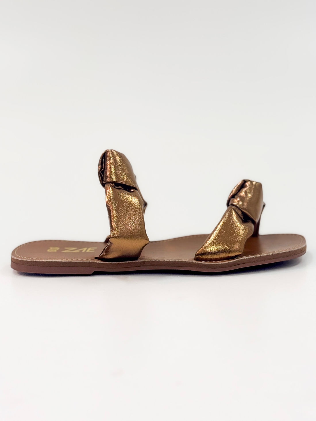 Luana — Chinelo Rasteira Bronze com Tiras Torcidas Luana — Chinelo Rasteira Bronze com Tiras Torcidas