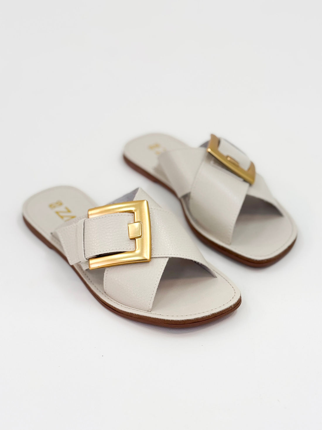 Joanice — Chinelo Rasteira Off White com Fivela Dourada Joanice — Chinelo Rasteira Off White com Fivela Dourada