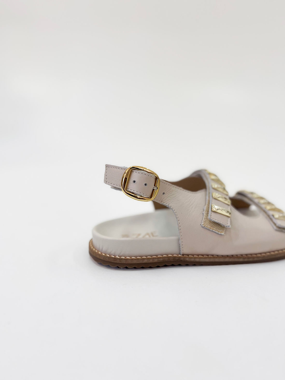 Zaza - Sandália Rasteira em Couro Off White com Tiras Douradas e Fivela Ajustável Zaza - Sandália Rasteira em Couro Off White com Tiras Douradas e Fivela Ajustável