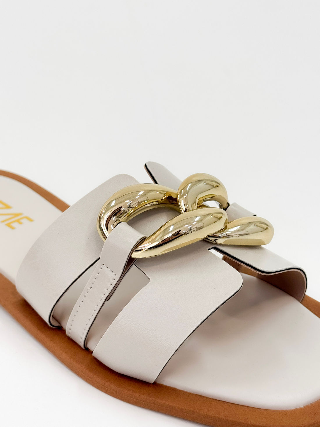 Clau – Chinelo Rasteira Off White com Detalhe Metálico Dourado Clau – Chinelo Rasteira Off White com Detalhe Metálico Dourado