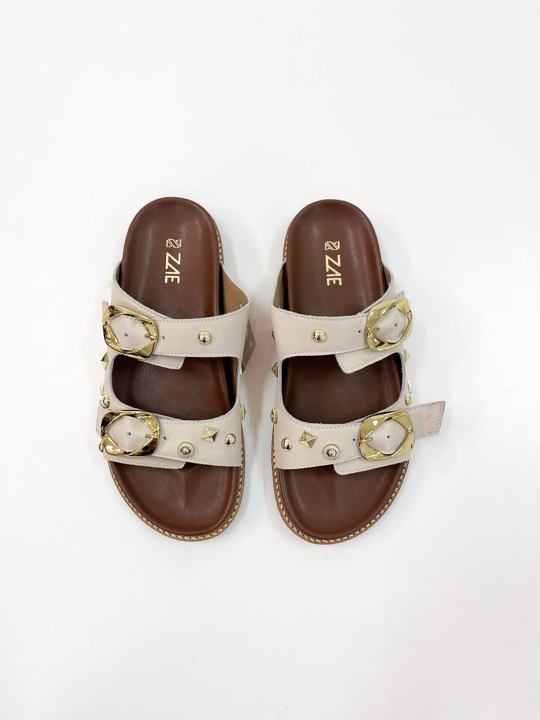 Emanuele - Rasteira Flat em Couro Off White com Tiras Largas e Fivelas Douradas Emanuele - Rasteira Flat em Couro Off White com Tiras Largas e Fivelas Douradas
