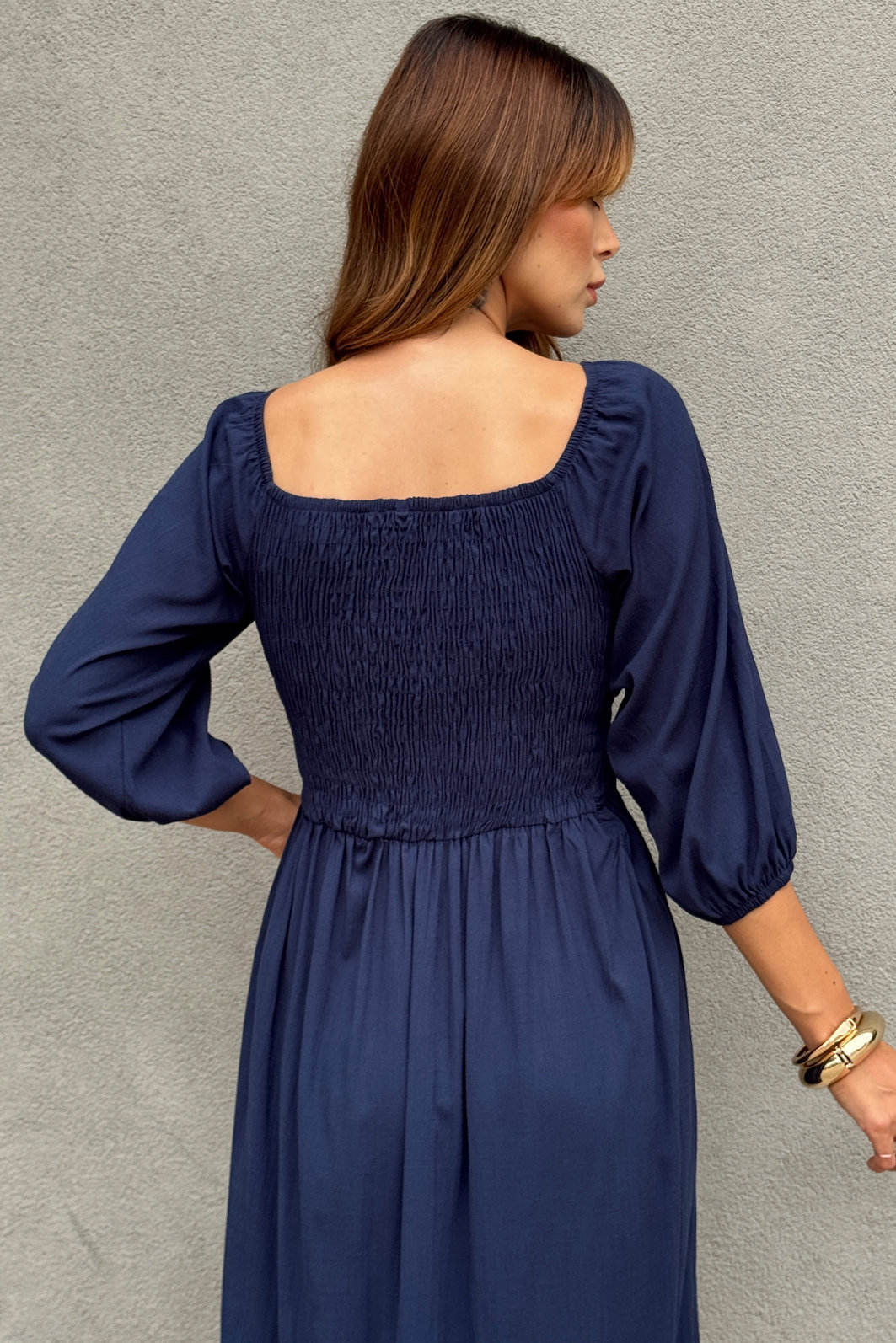 vestido midi azul marinho em viscolinho liso, busto com lastex, mangas ajustáveis e fenda lateral, caimento leve e fluido