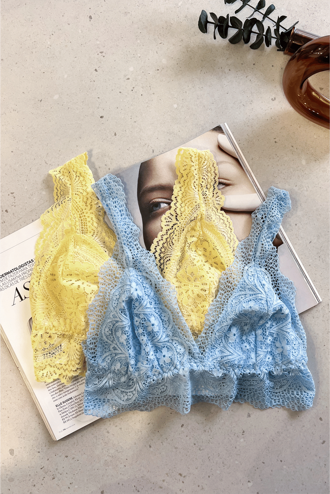 Top de Renda Chantilly MiniMoni – cor amarelo manteiga azul ceu Top de Renda Chantilly MiniMoni em cores rosa e branco, com renda delicada em design floral, apresentados lado a lado sobre revista.