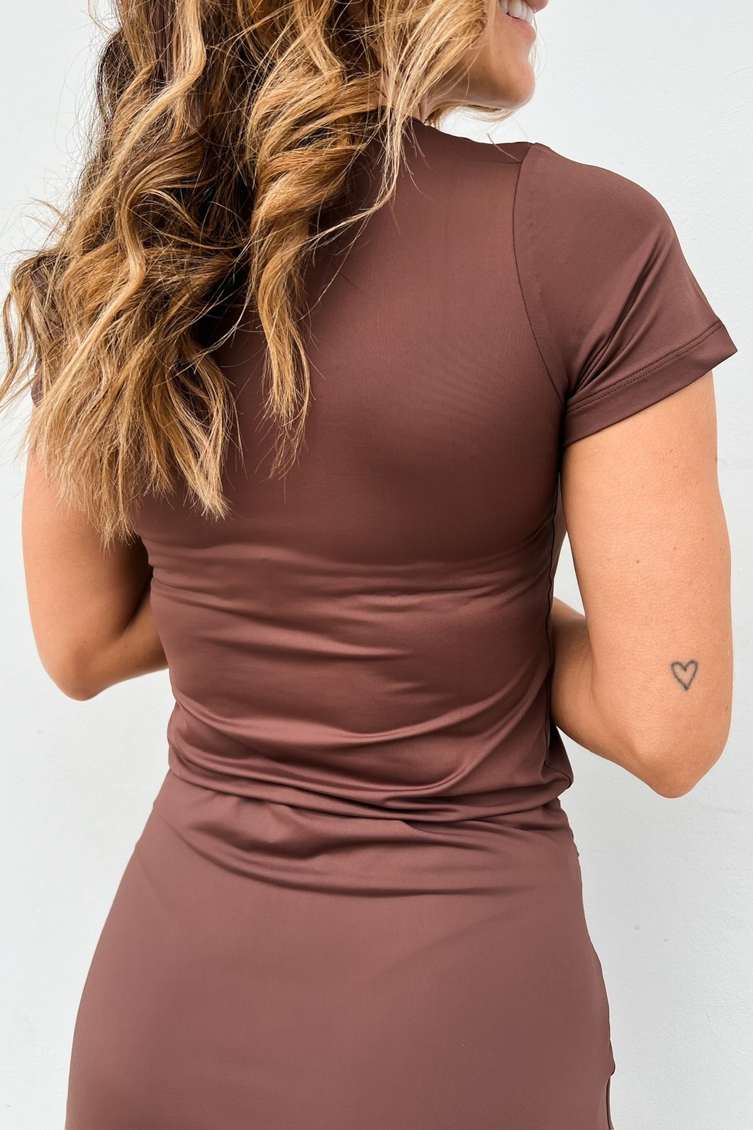 Vista de costas da Blusa Fit Eleonora, mostrando como a peça se ajusta e modela a silhueta de forma confortável.