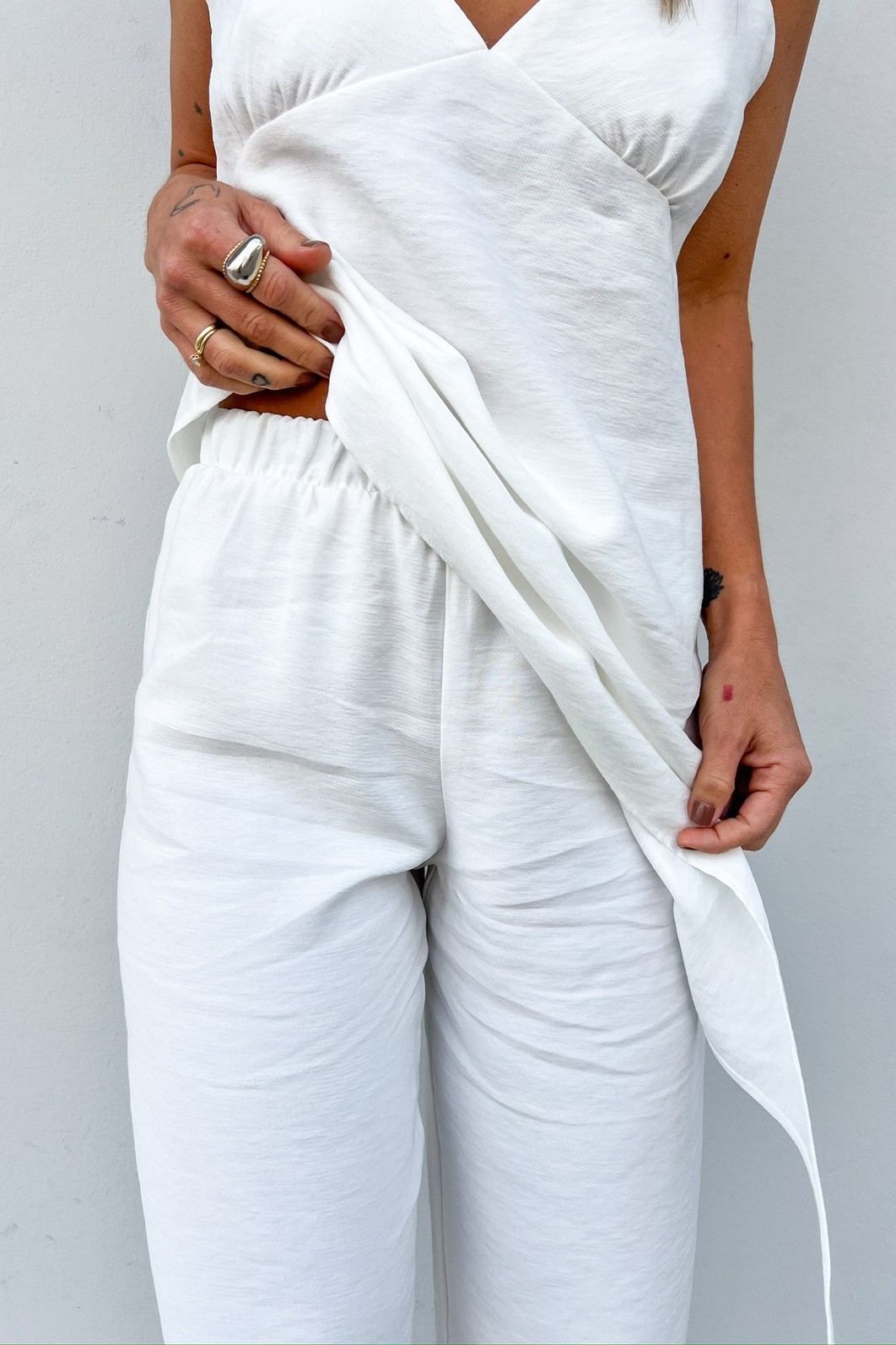 Detalhe do Cós com Elástico em Calça de Alfaiataria Branca lose-up da região da cintura da Calça Eleonora, destacando o cós com elástico que proporciona um ajuste confortável.