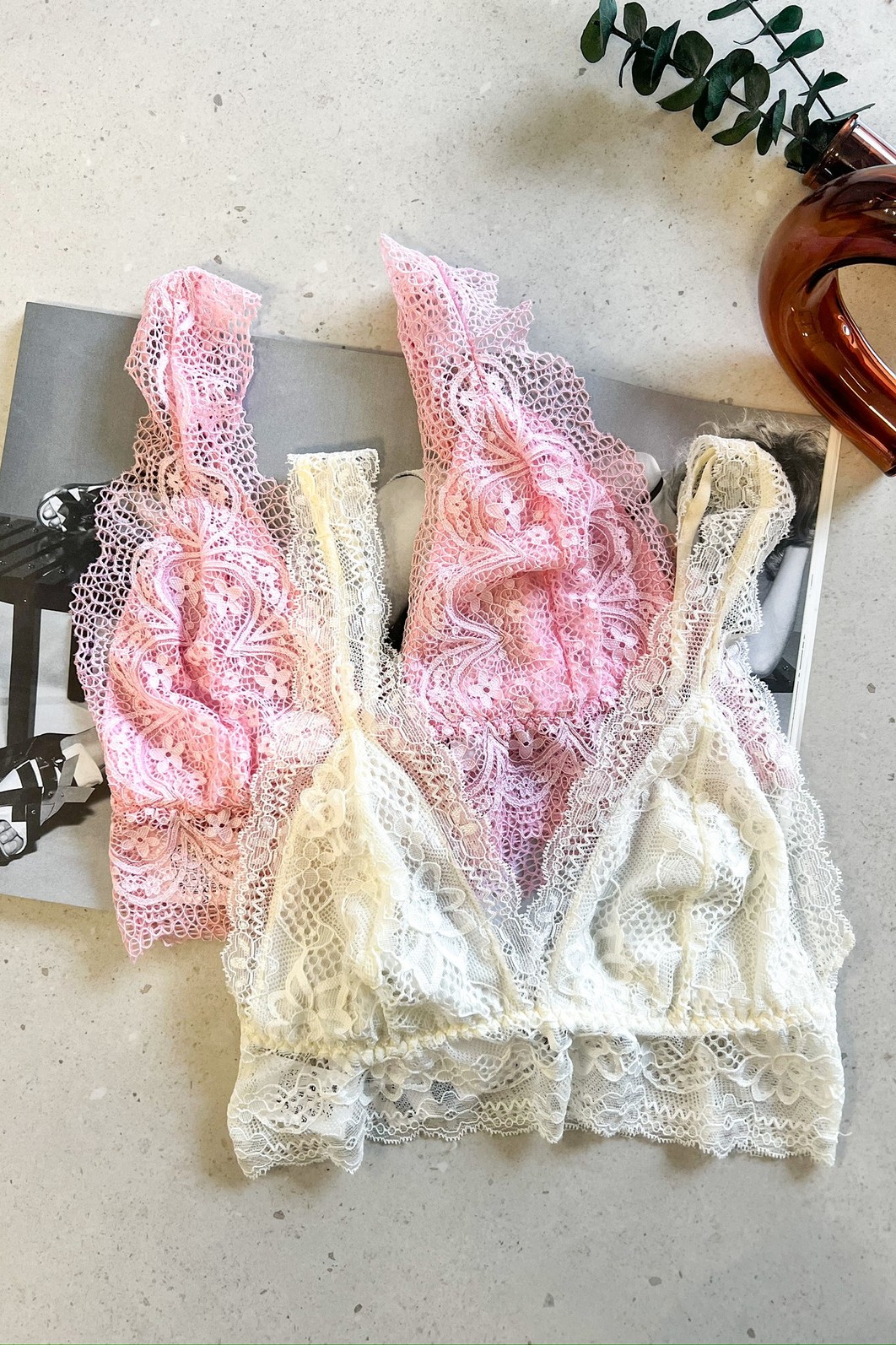 Top de Renda Chantilly MiniMoni – cores rosa e branco Top de Renda Chantilly MiniMoni em cores rosa e branco, com renda delicada em design floral, apresentados lado a lado sobre revista.