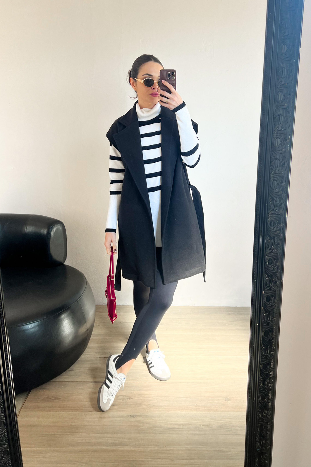 modelo usando blusão branco de gola alta com colete de lã batida e legging fusô