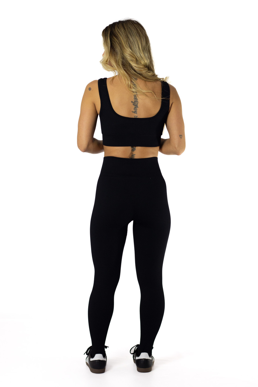 modelo de costas usando o conjunto de legging e top de academia sem costura de compressão preto