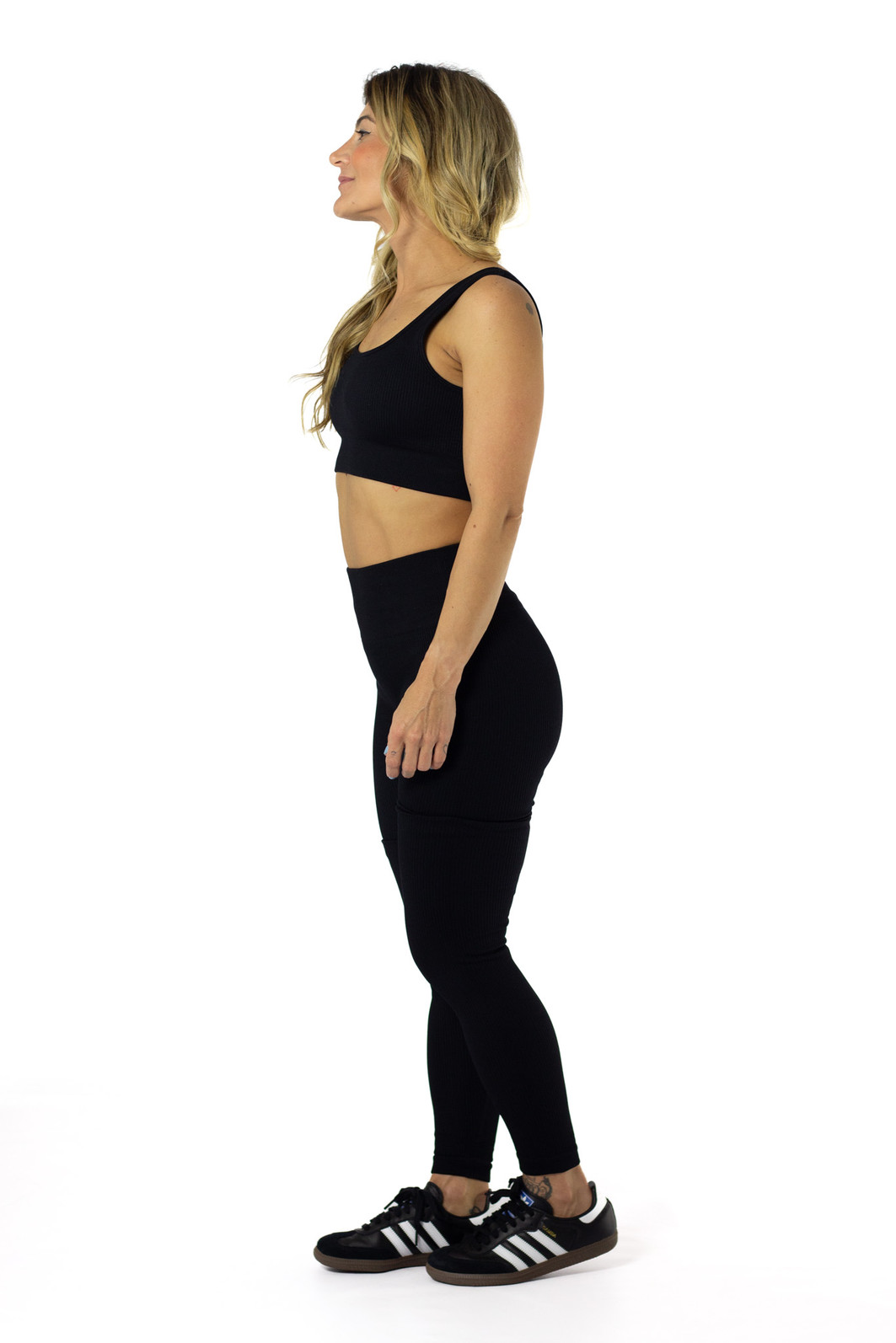 modelo de lado usando conjunto de legging e top de compressão preto