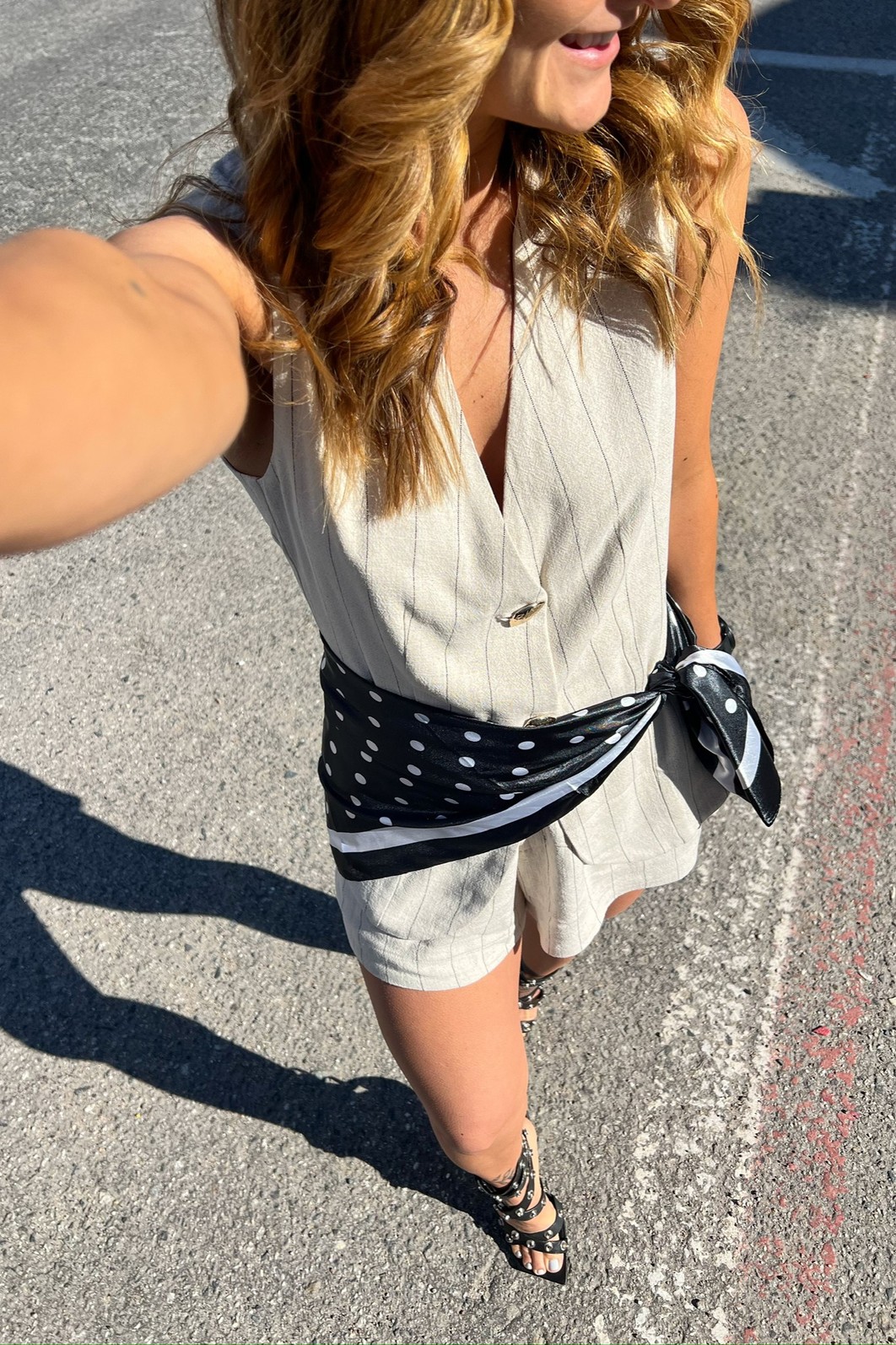 Look de Trabalho de Verão com Shorts de Linho Modelo combinando o Shorts Risca de Giz Nathalie com um lenço de seda amarrado na cintura, criando um look elegante e fresco para o dia a dia.