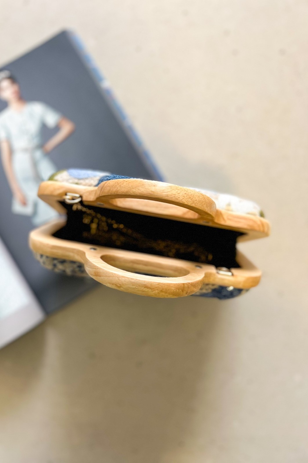 Bolsa Clutch Flora Azul com estrutura de madeira, vista de frente para mostrar os detalhes do bordado misto de linha e paetês.