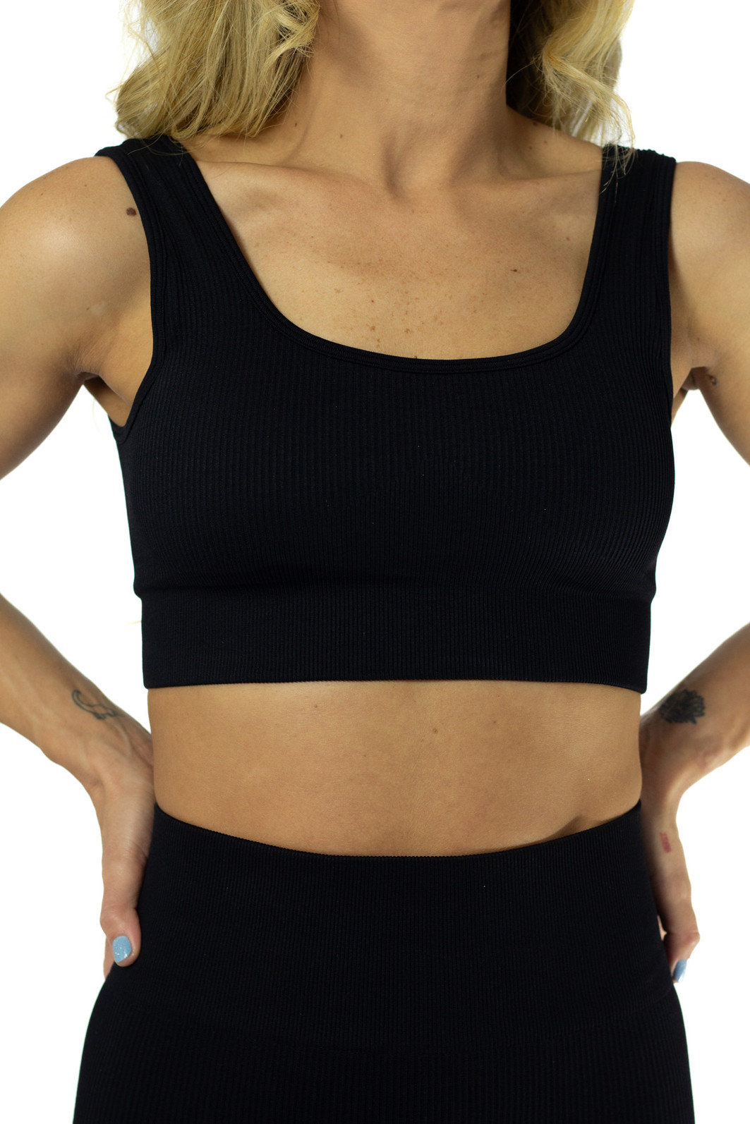 Modelo usando o top preto de compressão com bojo sem costura