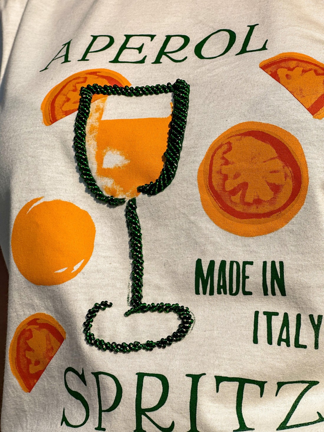 T-shirt Feminina Drink Aperol Cor Off White Bordada a Mão T-shirt Feminina Drink Aperol Cor Off White Bordada a Mão