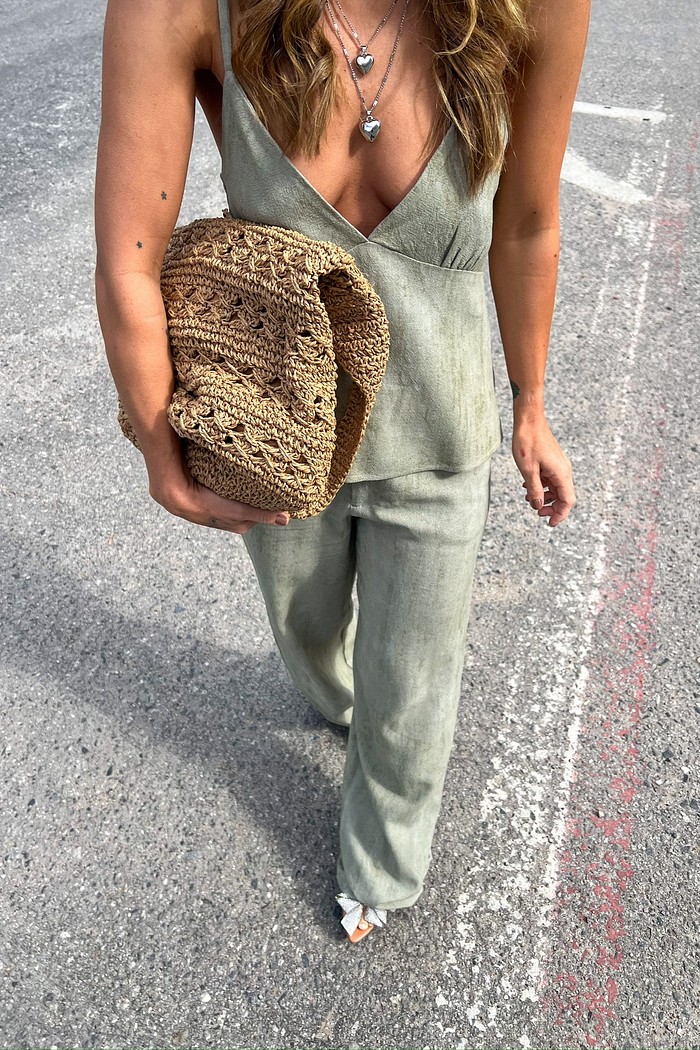 Vista do look completo da calça verde oliva com modelagem reta.