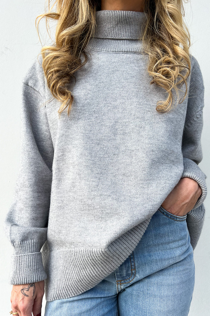 tricô cinza de gola alta e manga comprida com calça jeans 
