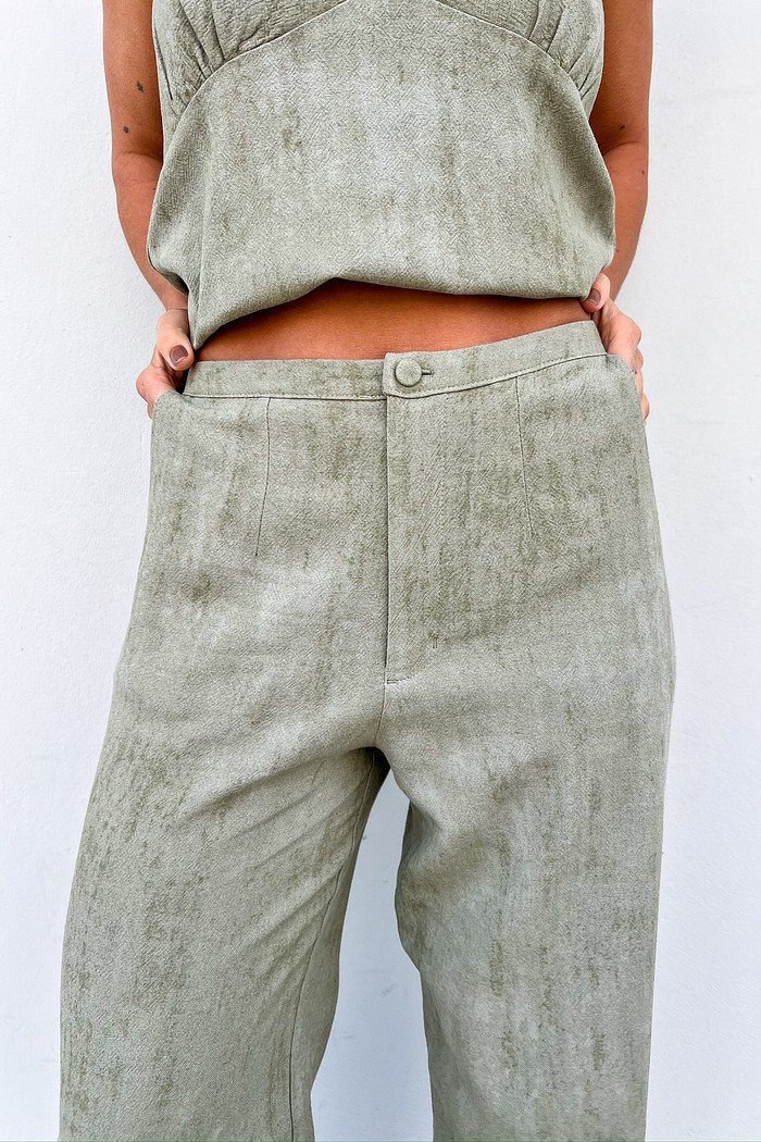 Detalhe lateral da calça mostrando bolsos faca e caimento reto.