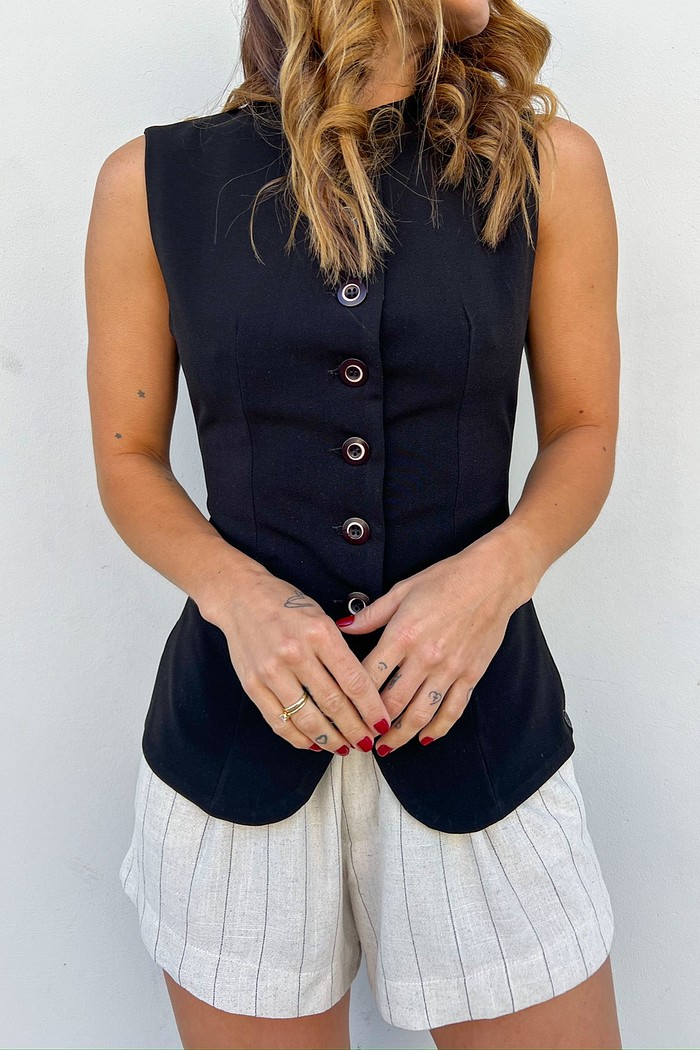 Colete de Alfaiataria Feminino Preto com Corte Alongado Modelo vestindo o Colete de Alfaiataria Preto Vivian fechado, mostrando o corte alongado e o detalhe dos botões frontais.