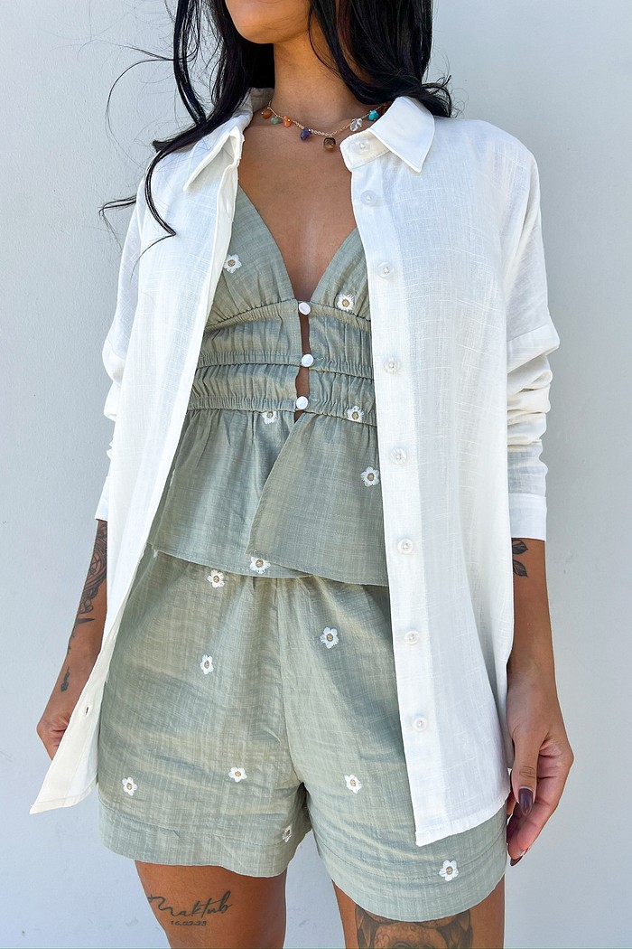 Camisa branca soltinha – conforto e estilo Camisa feminina branca de manga longa, modelagem soltinha, vista de costas, ideal para looks confortáveis e modernos.