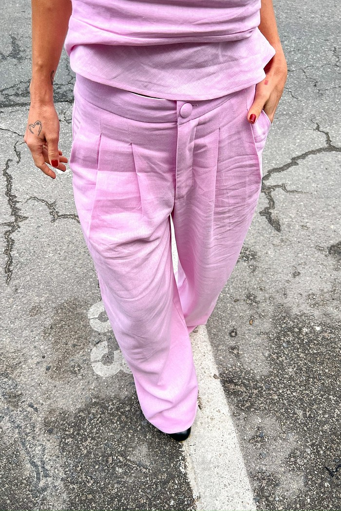 Calça de Alfaiataria Feminina Reta em Linho Rosa Modelo vestindo a Calça de Linho Rosa Eveline, mostrando o corte reto de alfaiataria e o caimento fluido do tecido.