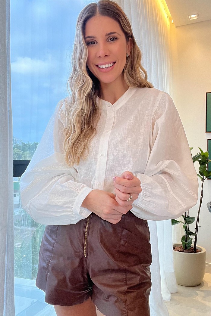 Camisa branca feminina com manga princesa e renda – MiniMoni Camisa branca feminina em linho e algodão MiniMoni, modelo manga princesa com renda delicada nas mangas e gola padre, perfeita para looks elegantes de trabalho e encontros casuais
