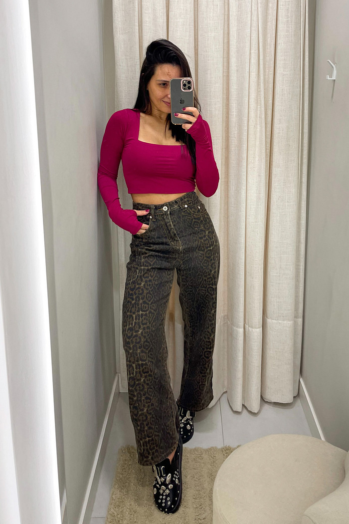 blusa cropped vermelho cereja manga longa bettina-2 Modelo em frente ao espelho usando cropped vermelho cereja de manga longa e gola quadrada e calça jeans de onça escura