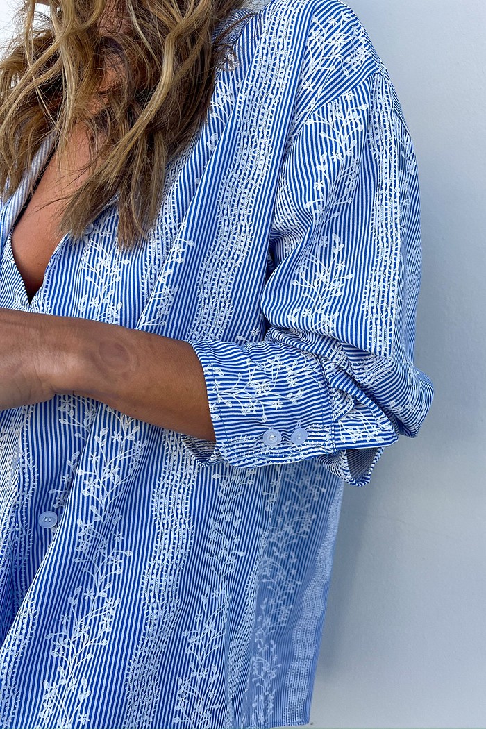 Detalhe da Estampa Exclusiva de Listras e Floral na Maxi Camisa Close-up dos botões personalizados MiniMoni e da estampa exclusiva de listras e floral.