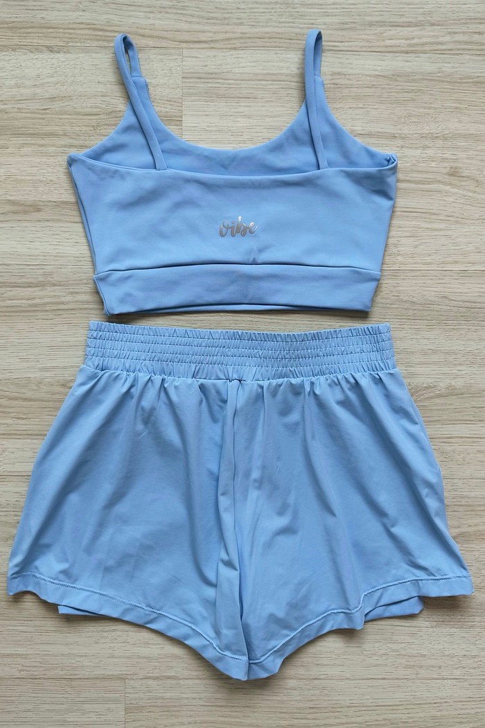 Modelo vestindo o Conjunto Top e Shorts Sky em azul céu: visual minimalista que une conforto esportivo e estilo casual.
